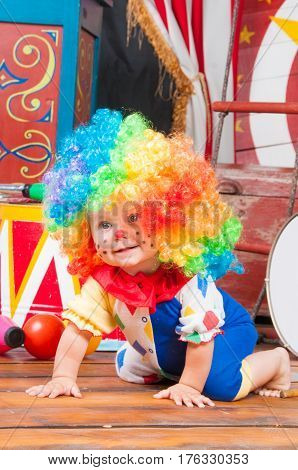 Little baby clown with red nose multi-colored wig in with balls.