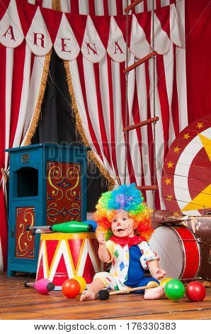 Little baby clown with red nose multi-colored wig in with balls.