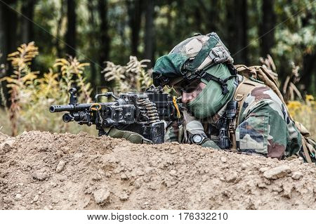 Machine gunner of 1st Marine Infantry Parachute Regiment RPIMA firing from defensive position trench