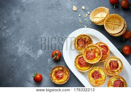 Cheese tomato tartlets puff pastry appetizers mini-pizzas with cheese and cherry tomatoes italian antipasti snack