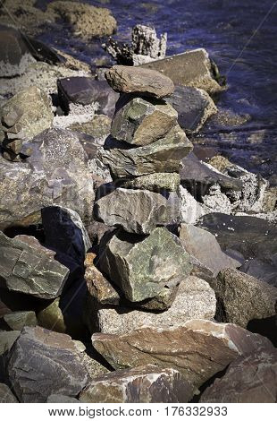 Vertical close up of large rocks on the shore of the Halifax Harbor on a bright sunny day in September in Halifax Nova Scotia.