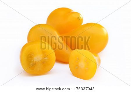 Yellow pear-shape cherry tomatoes whole and cut isolated on white