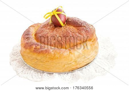 Typical italian flavorous home baked cake La Gubana with pasch egg decorated with yellow ribbon on lace napkin isolated over white. Traditionally bake for Easter. Horizontal copy space.