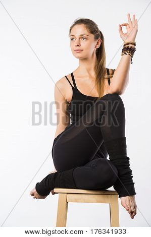 Sporty beautiful young woman sitting in Gomukhasana, Cowface pose, yin yoga Shoelace posture, asana for stretching hips and thighs, studio full length shot on white background, front view, isolated.