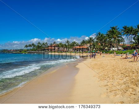 KAUAI, USA - MAR 3: Tourists and locals enjoy Poipu Beach on March 3, 2017 on Kauai, Hawaii. Poipu Beach is one of the most popular tourist areas on the island of Kauai and has many excellent hotels.