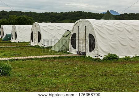 Kamchatka Peninsula, Russia - August 13, 2016: Tents for tourists on the source of river Ozernaya on Kurile lake. South Kamchatka Nature Park.