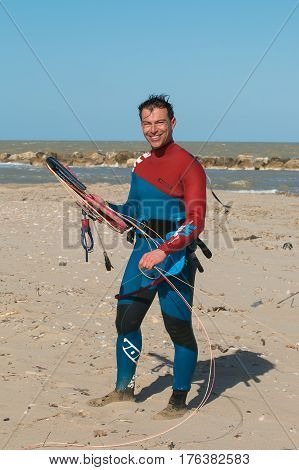 SAN BENEDETTO DEL TRONTO, MARCH 10, 2017: Happy smiling man with surfboard after the race