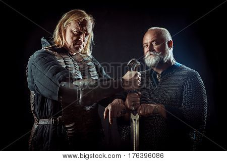 Two Powerful Knights Are Holding One Sword.