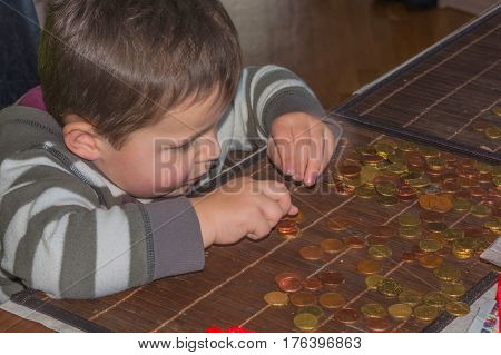 Child and a pile of money coins. Concept Save money.