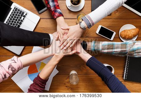 United hands team in office concept. Alliance and cooperation, casual business people connection, top view