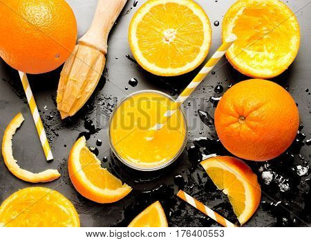 Fresh squezeed orange juice over black background top view