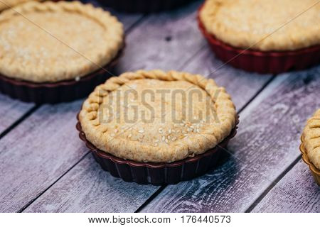 Apple pies of a round shape on a wooden table. close-up