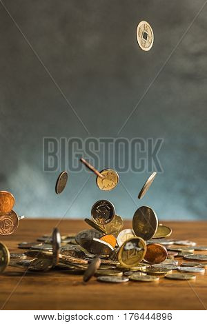 The silver and golden coins and falling coins on wooden table background