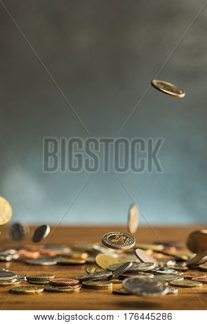 The silver and golden coins and falling coins on wooden table background