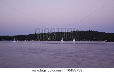 Sailboats are seen in distance in the Halifax Harbor late in the afternoon in Halifax Nova Scotia on a sunny day in September