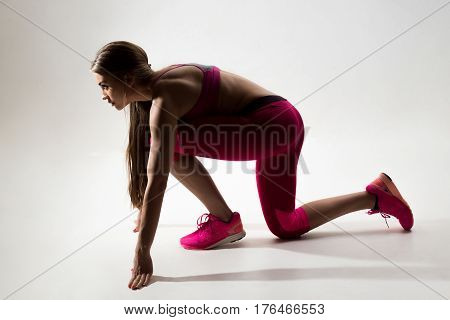 A Woman Dressed In Sportswear Prepared To Run. Studio. White Background.