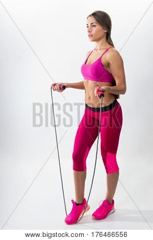 Woman In Sportswear Holding A Rope In His Hands. White Background. Studio.