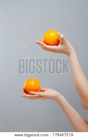 Chinese Orange on Asian woman hand on gray concrete background.