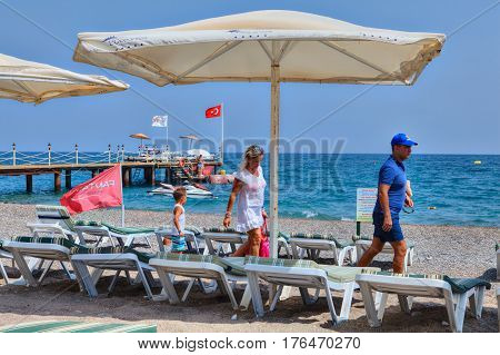 Antalya Turkey - 29 august 2014: A family of three people walks along a deserted beach.