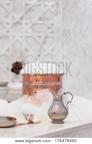 Water Jar, Towel And Copper Bowl With Soap Foam In Turkish Hamam. Traditional Interior Details