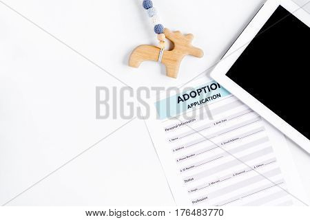 Adoption concept with tablet and children drawing on white table background top view mock-up