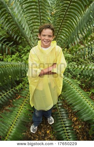 Dreng stående ved bregne