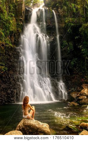 Young Woman In Bikini Sitting By Middle Tavoro Waterfalls In Bouma National Heritage Park, Taveuni I
