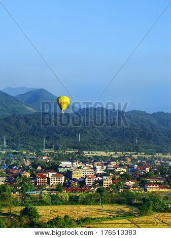 Hot air balloon flying above Vang Vieng town Vientiane Province Laos. Vang Vieng is a popular destination for adventure tourism in a limestone karst landscape.