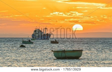 Sunset and boat on the sea as the sun slowly down the horizon circle creates a beautiful golden light on the bay. It's great to idyllic scenery here.