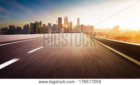 Highway overpass motion blur with city skyline background . Sunset scene .