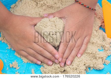 Child's Hand Close Up Playing Kinetic Sand
