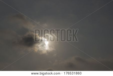 Sun shine in dark cloudy sky background.