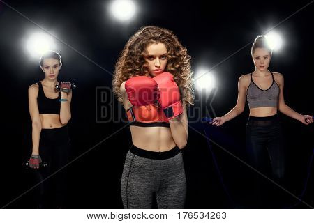 Attractive Sportswomen Boxing, Training With Dumbbells And Jumping On A Skipping Rope On Black