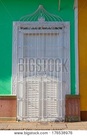 Typical colonial building with white window iron grate in Trinidad Cuba