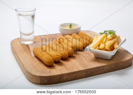Fish Sticks On A Wooden Board With Sauce And Fried Potatoes