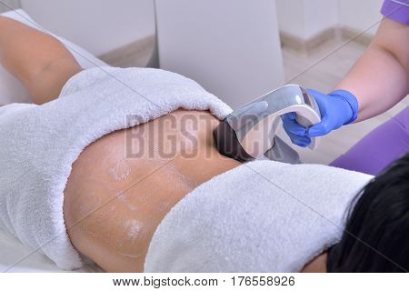 Young beautiful woman gets professional skin treatment in a professional beauty clinic. Body shaper