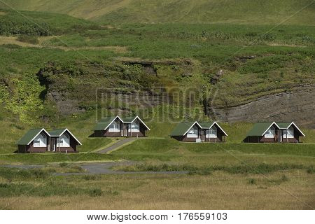 Landscape with Traditional iclandic wooden houses for turists on rock at the bottom of mountain.