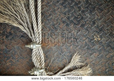 Old Ropes with U-Bolt Clamp on a rusty metal background