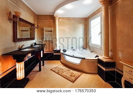 Luxurious bathroom in classic style with columns of Corinthian. Bathroom with two washbasins and a . The floors and walls with marble.