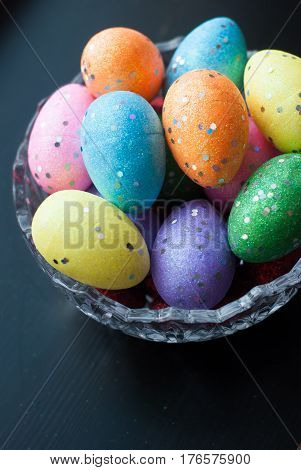 Easter Eggs In Crystal Dishes On A Black Wooden Background,