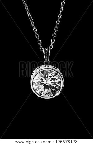Crystal pendant on silver chain isolated over black