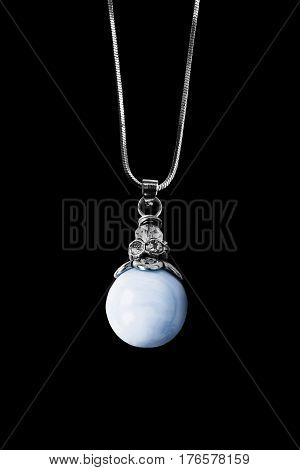 Blue pearl pendant on silver chain isolated over black