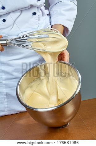 chef whips yellow cream in a bowl by hand for making cheesecakes complete series of food recipes