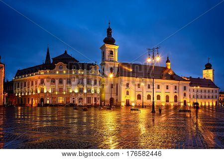 Sibiu city big square and it's impressive city hall on a rainy evening at blue hour time