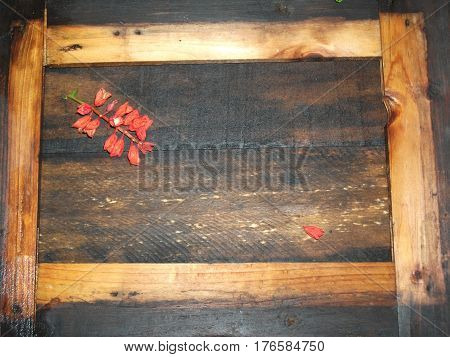 Composition with flowers and a wooden frame on a wooden background