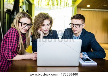 Young People In Modern Office Over Laptop Disscusing Or Planing, Browsing In Internet. Student Over