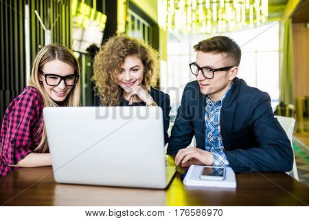 Young People In Modern Office Over Laptop Disscusing Or Planing, Browsing In Internet. Student Over