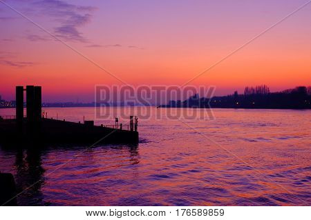Purple sunset reflected in the water of the river Scheld in Antwerp Belgium Europe