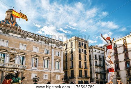 The Castellers de Barcelona of the Corpus Christi festival stand in front of the historical town hall with Giant puppets Gigantes and viewers.