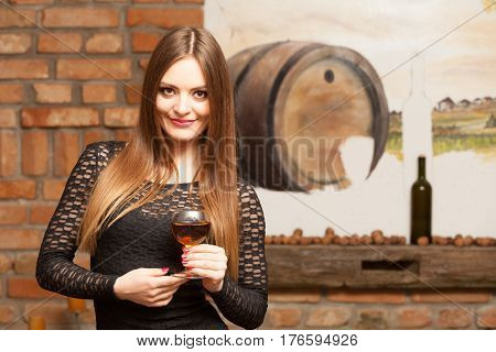 Woman Tasting Wine In Rural Cottage Interior